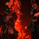 Three samurai warriors adorned in intricate armor and weaponry stand in front of a fire pit glittering with red embers.
